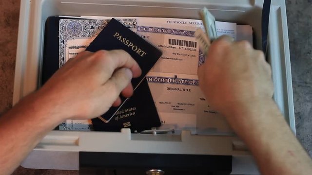 100 dollar bills are removed from a lock box and counted. Then a passport is looked at and then taken.