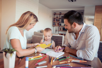 Mom,dad and son draw in the living room.
