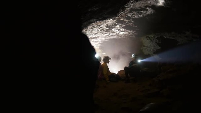 Children in helmets with lanterns explores the cave