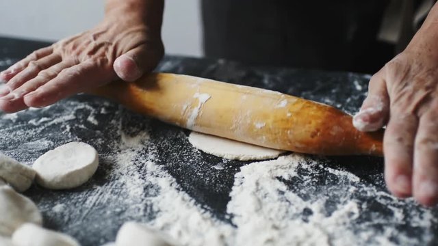 Woman rolling the dough by rolling, slow motion at 240 fps