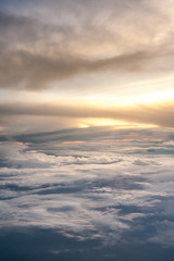 Fototapeta na wymiar Aerial view of a cloudy sunset while flying above the clouds
