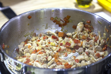 Fried chicken with vegetables in a large saucepan on the stove