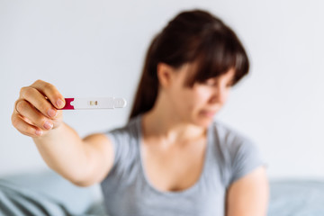 sad woman shows negative pregnancy test