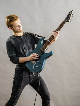Young man playing electric guitar