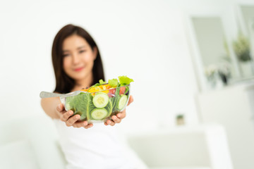 Asian woman holding healthy salad bowl.