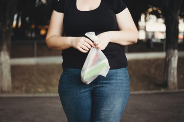 Overweight, sugar addiction, overeating. Overweight woman with plastic package of ice creams in...
