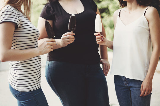 Social Overeating, Excessive Weight, Overeating, Obesity And Lifestyle. Overweight Woman Eating Ice Cream Together With Company Of Her Friends