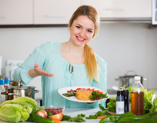 Young housewife with plate of cheese and salad