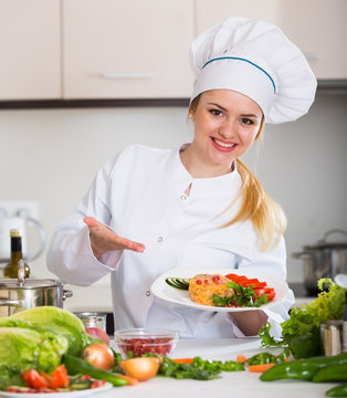 Positive chef posing with vegetable mix and cheese