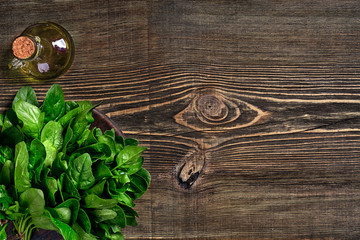 Spinach baby leaves on wooden background. Top view. Copy space
