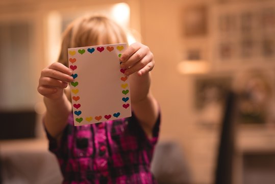 Girl holding heart shape valentine card