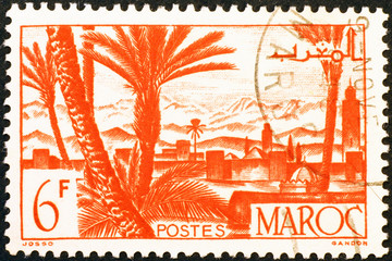 Moroccan village & palms on vintage postage stamp