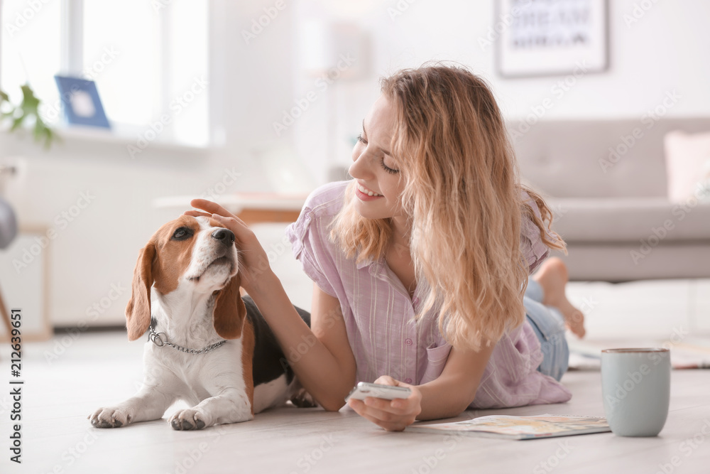 Wall mural young woman with her dog at home