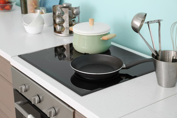 Electric stove with cooking utensils in kitchen