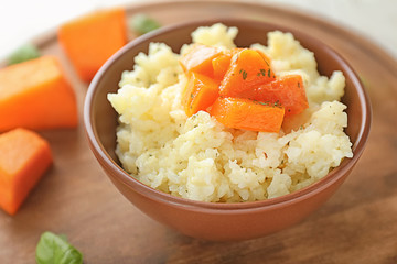 Bowl with delicious pumpkin risotto on table, closeup