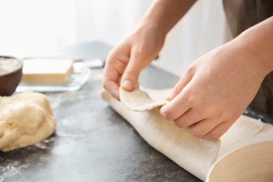 Woman working with dough on table, closeup