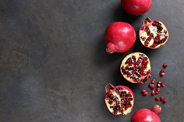 Pomegranate. Fresh ripe pomegranate overhead dark concrete background. Top view, copy space