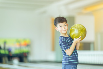 boy in bowling alley cheering and smiling