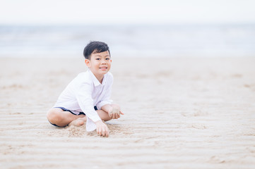 son playing with sand on the beach