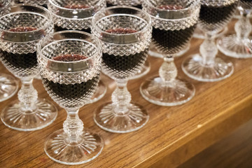Many ancient glasses with red wine.