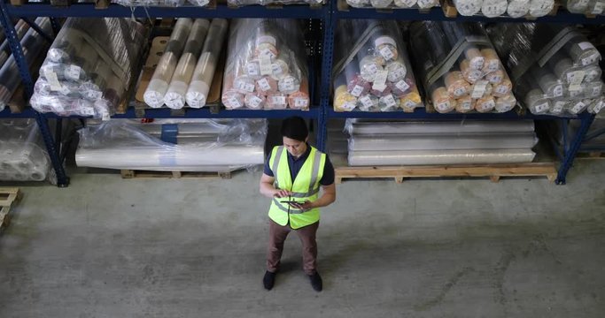 Male working in distribution warehouse with digital tablet