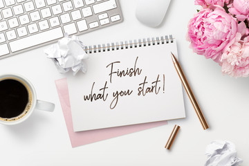 finish what you start - business concept. Notepad / ring binder, crumpled paper balls, mug with...