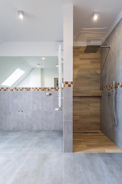 New bathroom interior in the house. Gray concrete tiles with wooden decor.