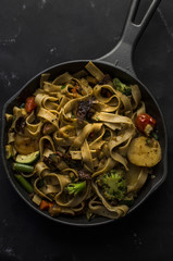Whole wheat pasta with vegetables on cast iron pan