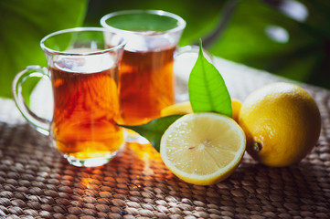 Fruits tea made from Limon , organic tea , fresh limon fruits whole and half on a natural tropical background.