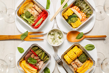 Healthy meal prep containers with vegetables, chicken, beef and shrimp grilled. Close-up, view top.