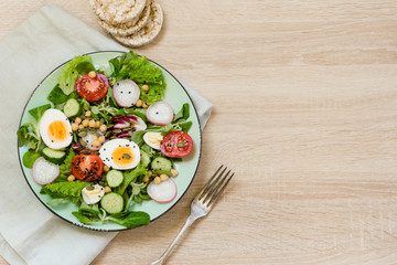 Fresh salad with vegetables and eggs for proper nutrition. Top view, copy space.
