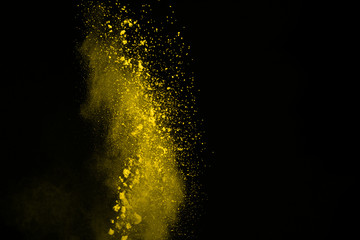 Abstract yellow powder splatted background,Freeze motion of color powder exploding color powder.
