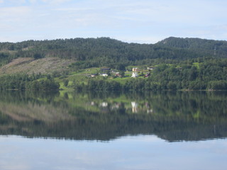 Reflection of houses and trees in crystal clear lake water...Norway