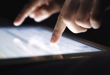Closeup fingers typing texting a message on tablet. Network, communication, technology concept