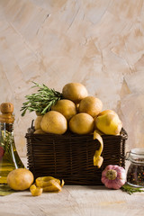 Wooden basket with potatoes and peels rosemary pepper