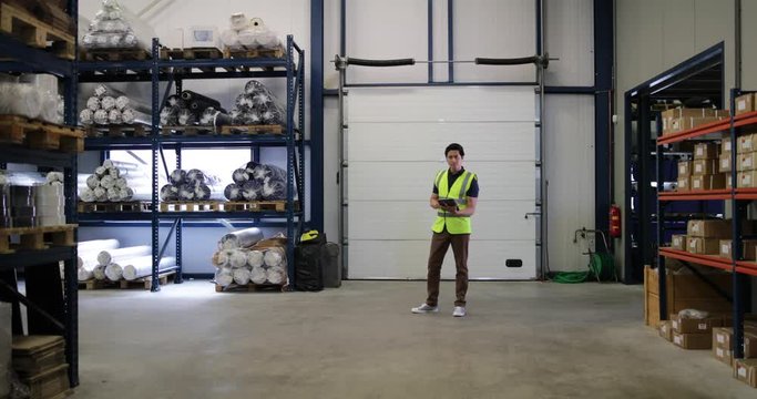Portrait of male working in distribution warehouse with digital tablet
