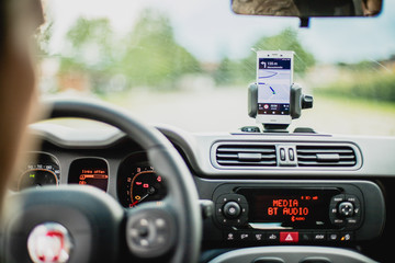Auto Cockpit von innen, Interieur, Hände am Lenkrad, Smartphone in Handyhalterung, Navigation 
