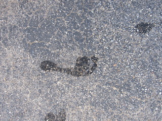 A wet footprint outside on the concrete 
