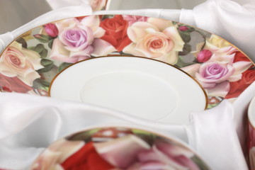 Tea Set with floral pattern in a box with white cloth close-up