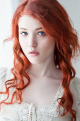 Tender retro portrait of a young beautiful dreamy redhead woman.