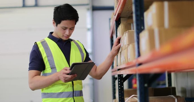 Male working in distribution warehouse with digital tablet