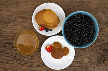 Pancakes with fruit. Breakfast with cakes. Pancakes in a pile on a plate. Currant, pancakes and honey.