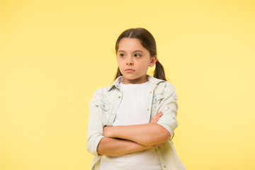 I do not want to see you. After dispute. Girl serious face offended yellow background. Kid unhappy...