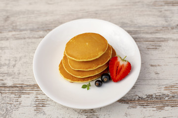 Pancakes with fruit. Breakfast with punkcakes. Pancakes in a pile on a plate.