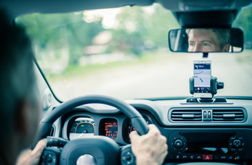 Auto Cockpit von innen, Interieur, Hände am Lenkrad, Smartphone in Handyhalterung, Navigation 