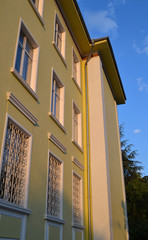 Fototapeta premium Fragment of the facade of the recently restored building of the first quarter of the last century. The building is painted in yellow, the decoration details are white