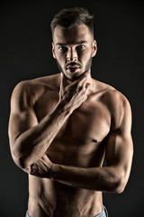 Fototapeta na wymiar What if I will show you my muscles. Man thoughtful face looks attractive black background. Athlete sexy muscular body on confident face. Man muscular torso tense muscles veins touch chin while think