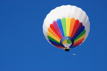 White and colorful hot air balloon. Background blue sky