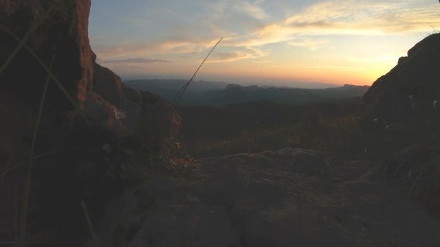 Mountain sunset over the peak rock. Dark key sunset light in the mountains parallax rocks rock grass
