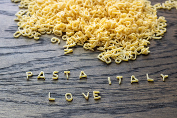 Raw alphabet pasta. Pasta Italy Love written in alphabet pasta. Words made from alphabet pasta.